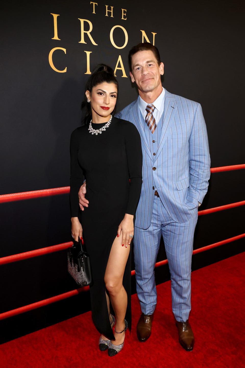 Shay Shariatzadeh in black dress and John Cena in blue suit at "The Iron Claw" premiere