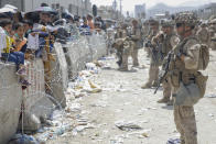 In this image provided by the U.S. Marines, U.S. Marines with Special Purpose Marine Air-Ground Task Force - Crisis Response - Central Command, provide assistance during an evacuation at Hamid Karzai International Airport in Kabul, Afghanistan, Friday, Aug. 20, 2021. (Lance Cpl. Nicholas Guevara/U.S. Marine Corps via AP)