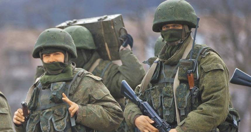 俄羅斯曾於2014年入侵烏克蘭東部和吞併克里米亞，圖為當年克里米亞的親俄部隊接近一座烏軍基地時，一名士兵比出象徵勝利的手勢。（圖／美聯社）