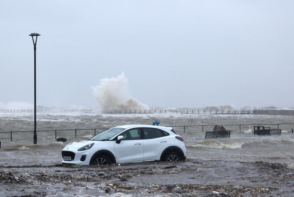 A car drives through floodwaters this week in Brighton (Reuters)