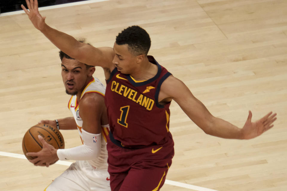 Atlanta Hawks guard Trae Young (11) gets pressured by Cleveland Cavaliers guard Dante Exum (1) during the first half of an NBA basketball game on Saturday, Jan. 2, 2021 in Atlanta. (AP Photo/Ben Gray)