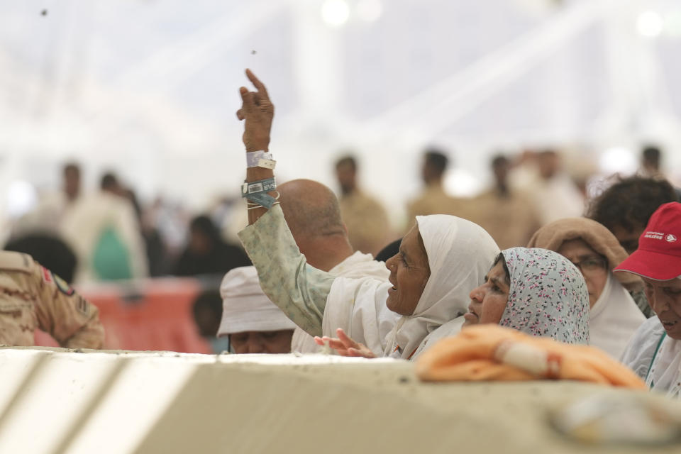 Muslim pilgrims cast stones at pillars in the symbolic stoning of the devil, the last rite of the annual hajj, in Mina, near the holy city of Mecca, Saudi Arabia, Sunday, June 16, 2024. Masses of pilgrims on Sunday embarked on a symbolic stoning of the devil in Saudi Arabia. The ritual marks the final days of the Hajj, or Islamic pilgrimage, and the start of the Eid al-Adha celebrations for Muslims around the world. (AP Photo/Rafiq Maqbool)