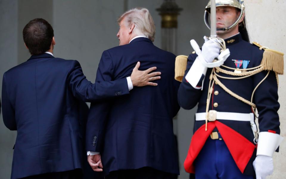 French President Emmanuel Macron (L) shares a laugh with US President Donald Trump