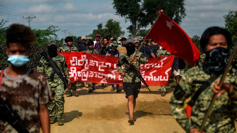 Anti-coup fighters escort protesters as they take part in a demonstration against the military coup in Sagaing, Myanmar on September 7, 2022. - Stringer/AFP/Getty Images