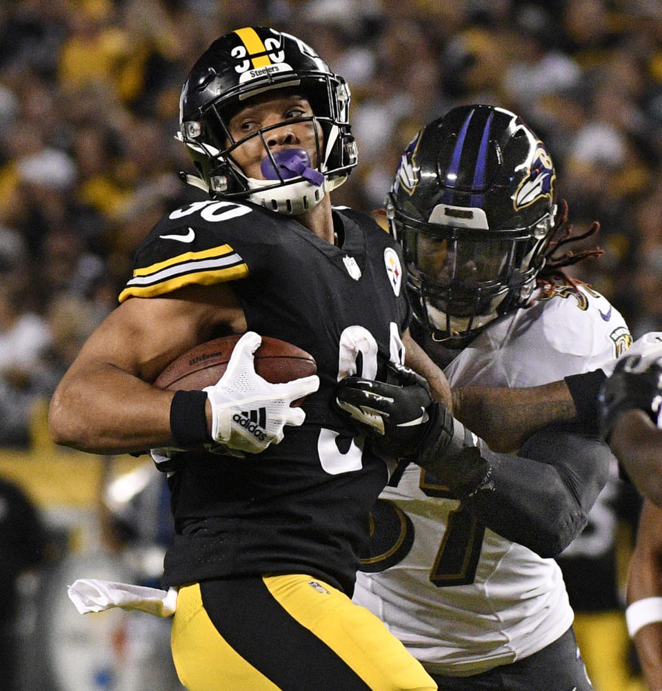 Pittsburgh Steelers running back James Conner (30) spins away from Baltimore Ravens linebacker C.J. Mosley (57) on a run during the first half of an NFL football game in Pittsburgh, Sunday, Sept. 30, 2018. (AP Photo/Don Wright)