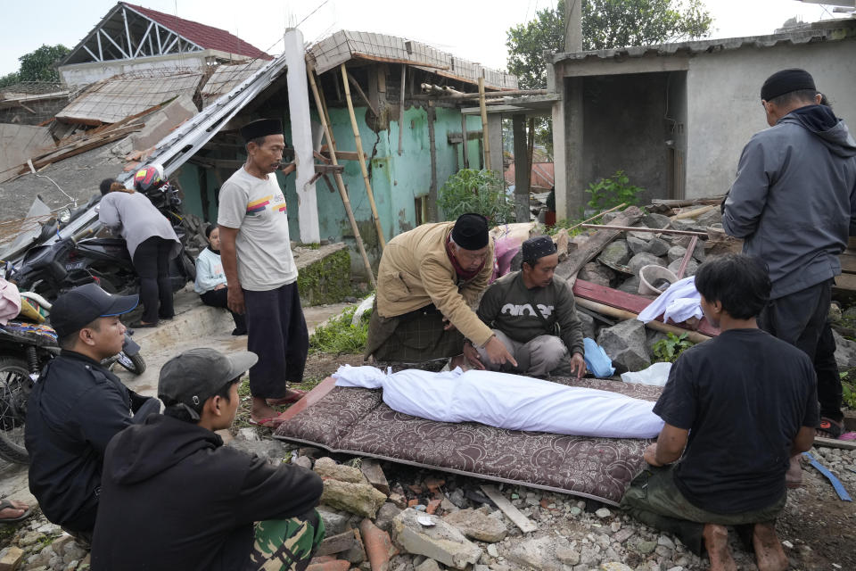 Men prepare the body of a young earthquake victim for burial in Cianjur, West Java, Indonesia Tuesday, Nov. 22, 2022. The earthquake has toppled buildings on Indonesia's densely populated main island, killing a number of people and injuring hundreds. (AP Photo/Tatan Syuflana)