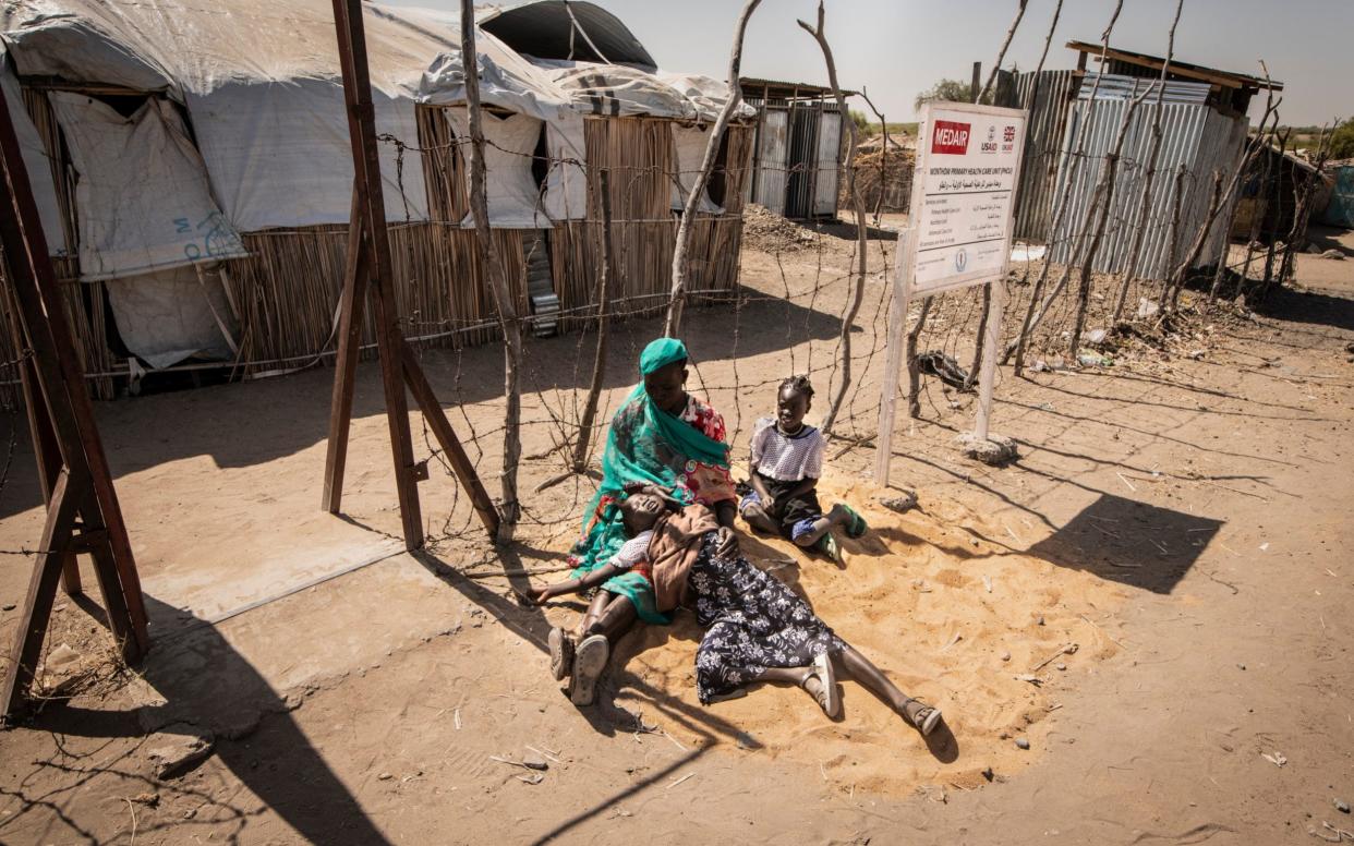 A mother with her daughter, who has malaria, waiting for treatment at a clinic in South Sudan - Simon Townsley