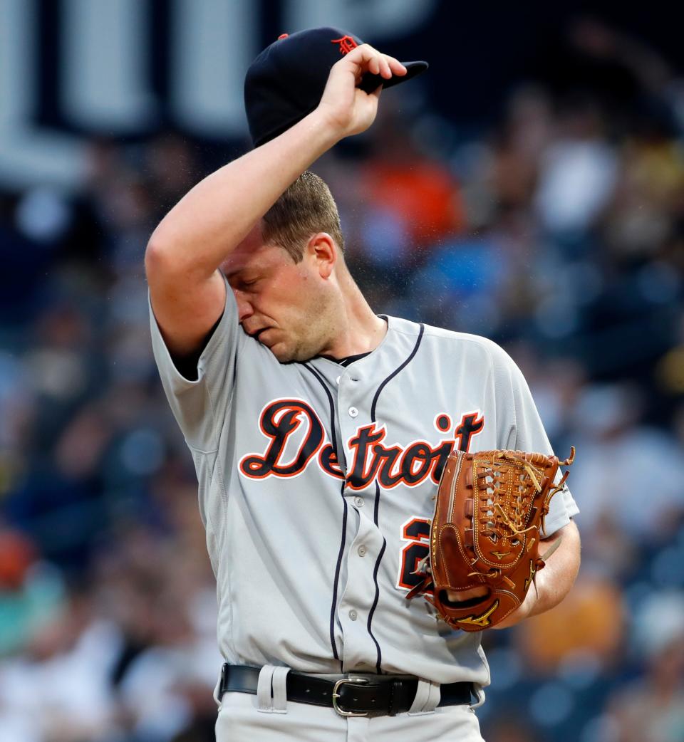 Detroit Tigers starting pitcher Jordan Zimmerman wipes his face between pitches during the third inning of the team's baseball game against the Pittsburgh Pirates in Pittsburgh, Wednesday, June 19, 2019.