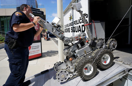 A Cleveland police bomb squad technician loads a Remotec F5A explosive ordnance device robot during a demonstration of police capabilities near the site of the Republican National Convention in Cleveland. REUTERS/Rick Wilking