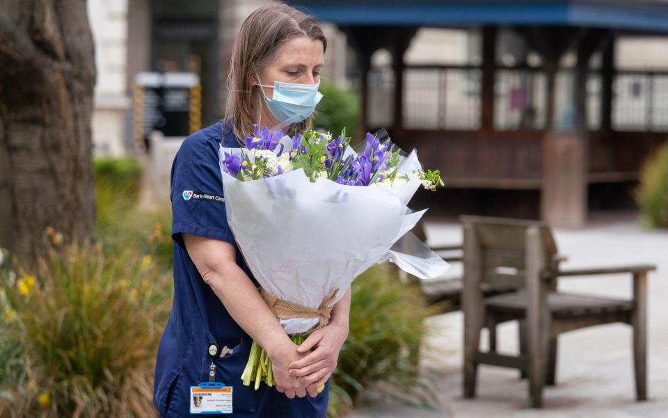 Staff at St Bartholomew's Hospital, London, receive flowers from Queen Elizabeth II on the anniversary of the first national lockdown - Dominic Lipinski/PA