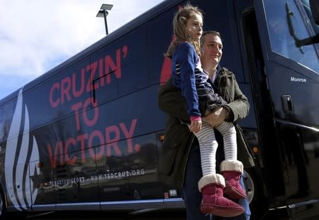 Ted Cruz carries his daughter Caroline as he arrives at a campaign event in Jefferson, Iowa. REUTERS/Jim Young