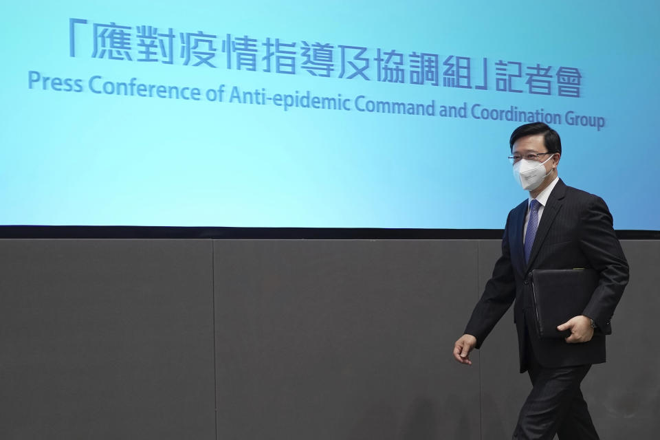 Hong Kong Chief Executive John Lee arrives for a news conference in Hong Kong, Monday, Aug. 8, 2022. Lee said Monday that the length of mandatory hotel quarantine for overseas arrivals will be reduced to three days from a week. (AP Photo/Kin Cheung)