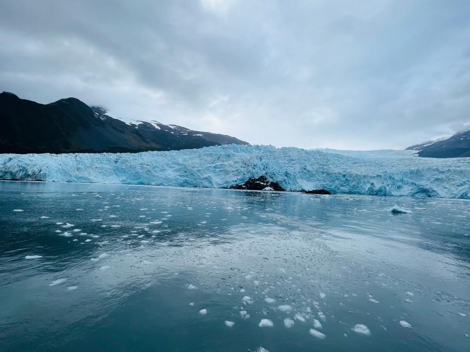 A large glacier is surrounded by icy waters. 