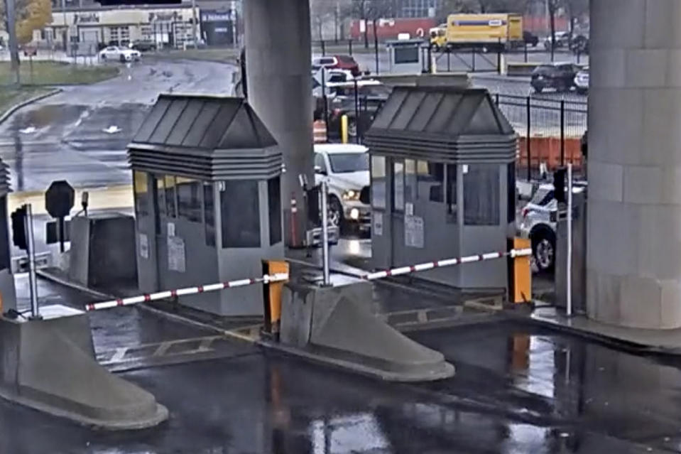 In this photo taken from security video, a light colored vehicle, top left, travels toward the Rainbow Bridge customs plaza, Wednesday, Nov. 22, 2023, in Niagara Falls, N.Y. A vehicle exploded at a checkpoint on the American side of a U.S.-Canada bridge in Niagara Falls Wednesday, leaving two people dead and prompting the closing of four border crossings in the area, authorities said. (Customs Border Protection via AP)