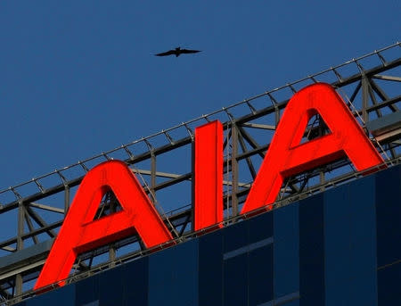 FILE PHOTO: A bird flies over AIA Tower, named after American International Assurance Co (AIA), in Hong Kong February 27, 2009. REUTERS/Bobby Yip/File Photo