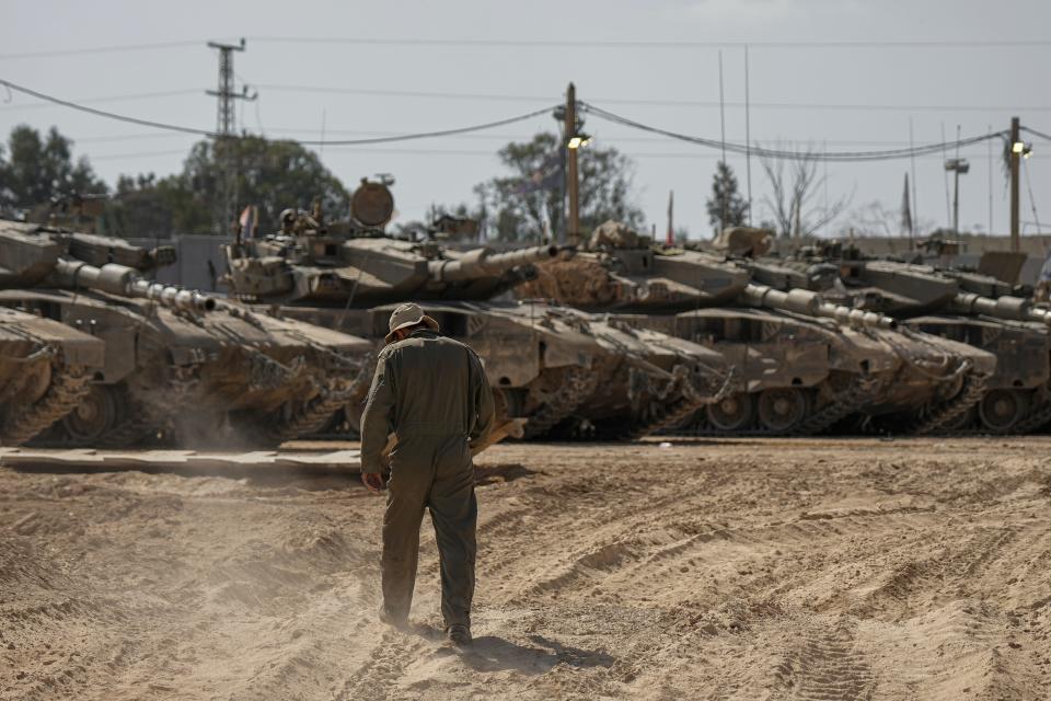 Israeli soldiers work on tanks at a staging ground near the border with the Gaza Strip in southern Israel on April 11, 2024.
