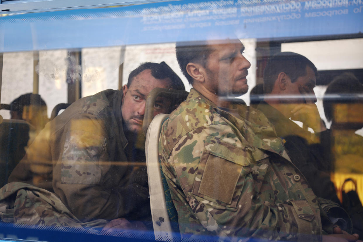 Ukrainian servicemen sit in a bus after they were evacuated from Mariupol's besieged Azovstal steel plant, near a remand prison in Olyonivka, in territory controlled by Russia in eastern Ukraine.