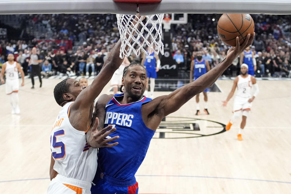 Los Angeles Clippers forward Kawhi Leonard, right, shoots as Phoenix Suns forward Kevin Durant defends during the second half of an NBA basketball game Monday, Jan. 8, 2024, in Los Angeles. (AP Photo/Mark J. Terrill)