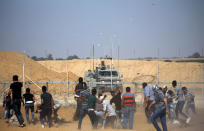 Palestinian demonstrators hurl stones at Israeli troops during a protest demanding the right to return to their homeland at the Israel-Gaza border, in the southern Gaza Strip August 17, 2018. REUTERS/Ibraheem Abu Mustafa