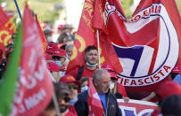 Demonstrators take part in a march organized by Italy's main labor unions, in Rome's St. John Lateran square, Saturday, Oct. 16, 2021. The march was called a week after protesters, armed with sticks and metal bars, smashed their way into the headquarters of CGIL, a left-leaning union, and trashed its office, during a demonstration to protest a government rule requiring COVID-19 vaccines or negative tests for workers to enter their offices. (AP Photo/Andrew Medichini)