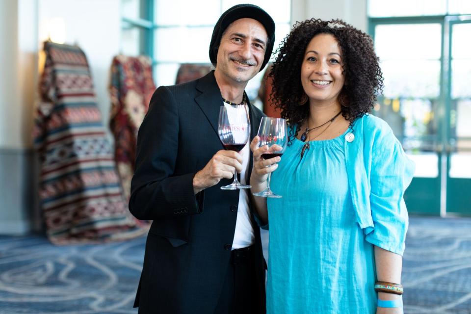 A man and a woman hold up glasses of wine