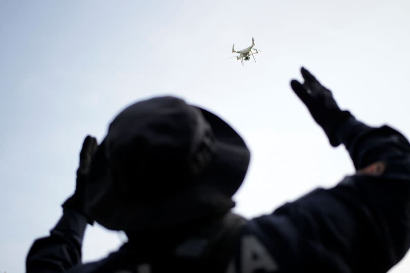 A police officer uses a drone during a search for skeletal remains and clothing at a plot of land in the municipality of Hidalgo