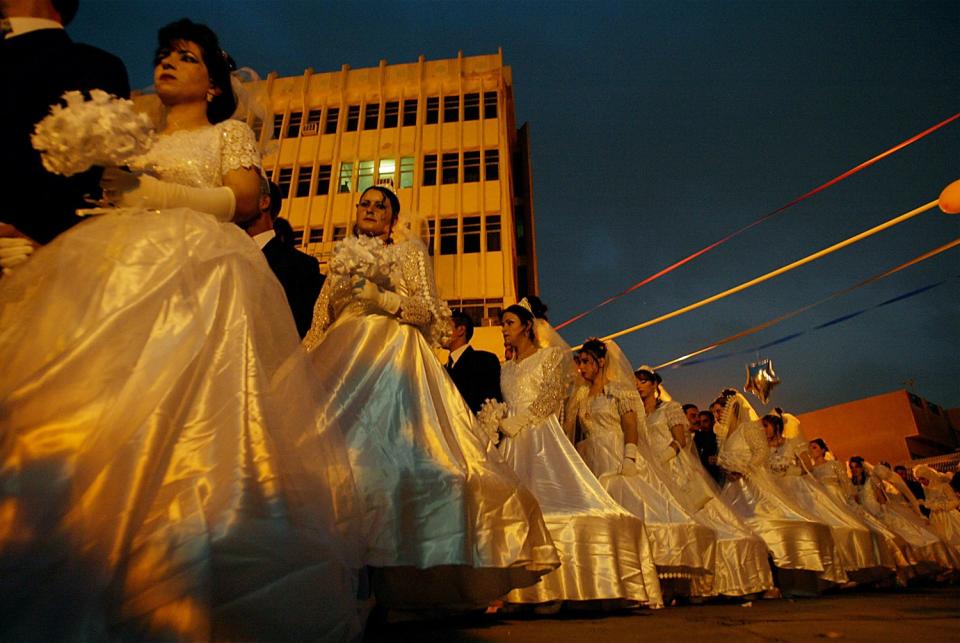 A line of couples in wedding attire