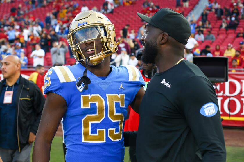 LOS ANGELES, CA - NOVEMBER 18: UCLA Bruins running back TJ Harden (25) gets a hug.