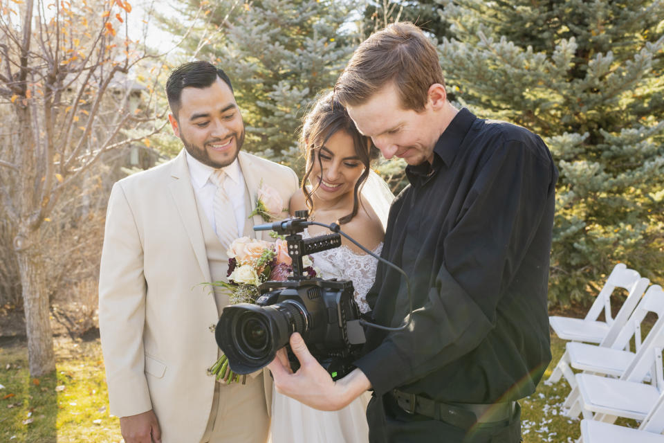 photographer showing a bride and groom their photos
