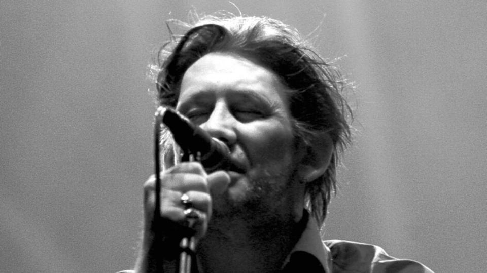 Shane Macgowan performing on stage with The Pogues