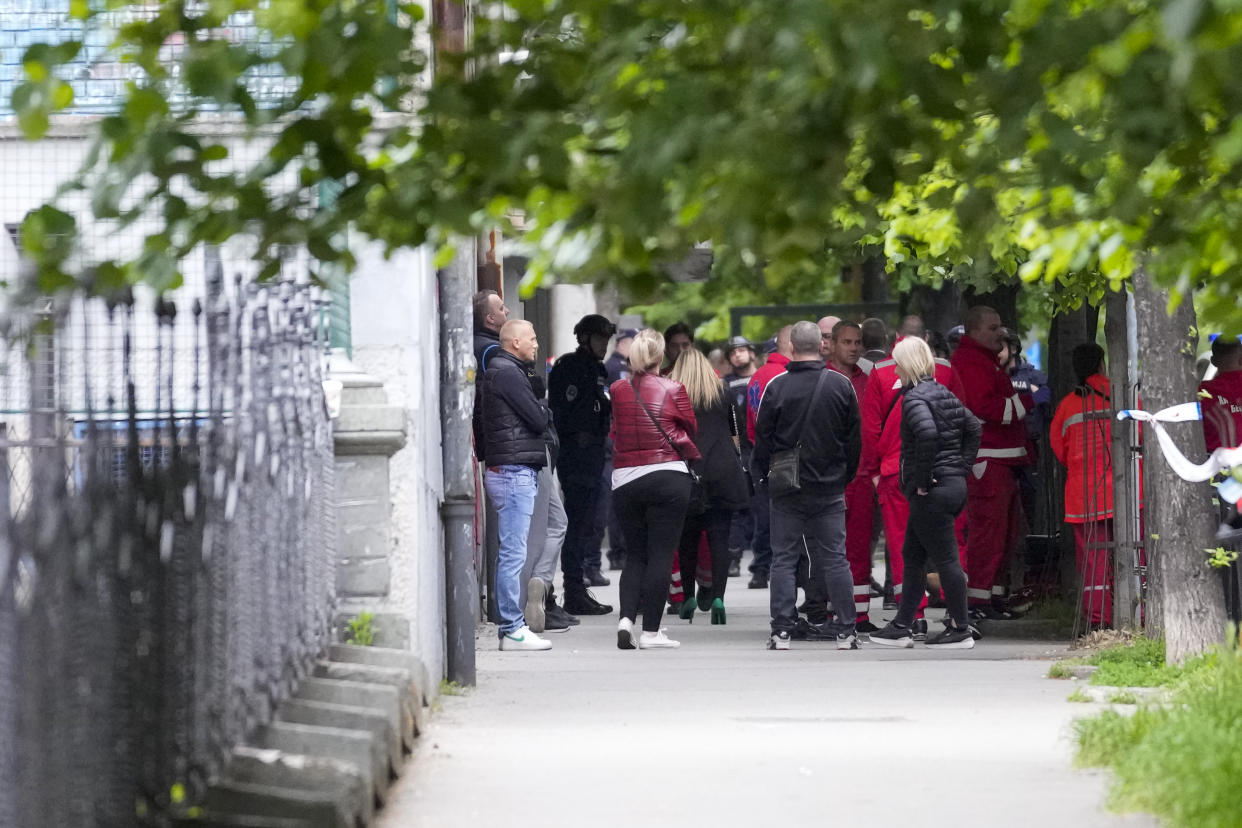 Police and medics stand in front of the Vladislav Ribnikar school in Belgrade, Serbia, Wednesday, May 3, 2023. A teenage boy opened fire early Wednesday in a school in central Belgrade, causing injuries. (AP Photo/Darko Vojinovic)