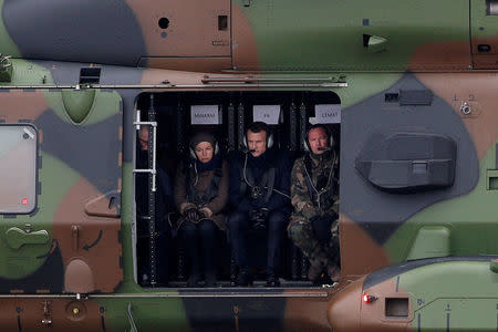 FILE PHOTO: French President Emmanuel Macron (C), Minister of the Armed Forces Florence Parly (L) and General Jean-Pierre Bosser, Chief of Staff of the French land forces (chef d'etat-major de l'armee de terre, CEMAT), fly in a NH90 helicopter during a military exercise over the military camp of Suippes, near Reims, France, March 1, 2018. REUTERS/Yoan Volat/Pool/File Photo