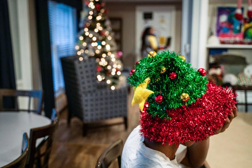 A 14-year-old boy, whose identity is kept anonymous for safety reasons, wears a Christmas hat to decorate cookies at Christ Child House in Detroit on Monday, Dec. 12, 2022.