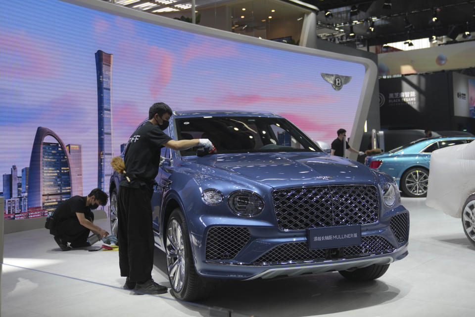 Workers prepare at a Bentley booth for the upcoming auto show to be held in Beijing, China, Wednesday, April 24, 2024. Foreign automakers have been caught flat-footed in China by an electric vehicle boom that has shaken up the market over the last three years. That has left manufacturers like Volkswagen scrambling to develop new models for a very different market than at home. (AP Photo/Tatan Syuflana)