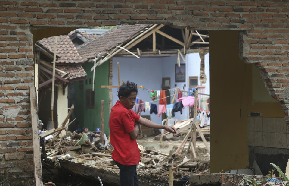 A man views the destruction to his home in the tsunami-hit village of Carita, Indonesia, Friday, Dec. 28, 2018. Indonesia has widened the no-go zone around an island volcano that triggered a tsunami on the weekend, killing hundreds of people in Sumatra and Java. (AP Photo/Achmad Ibrahim)