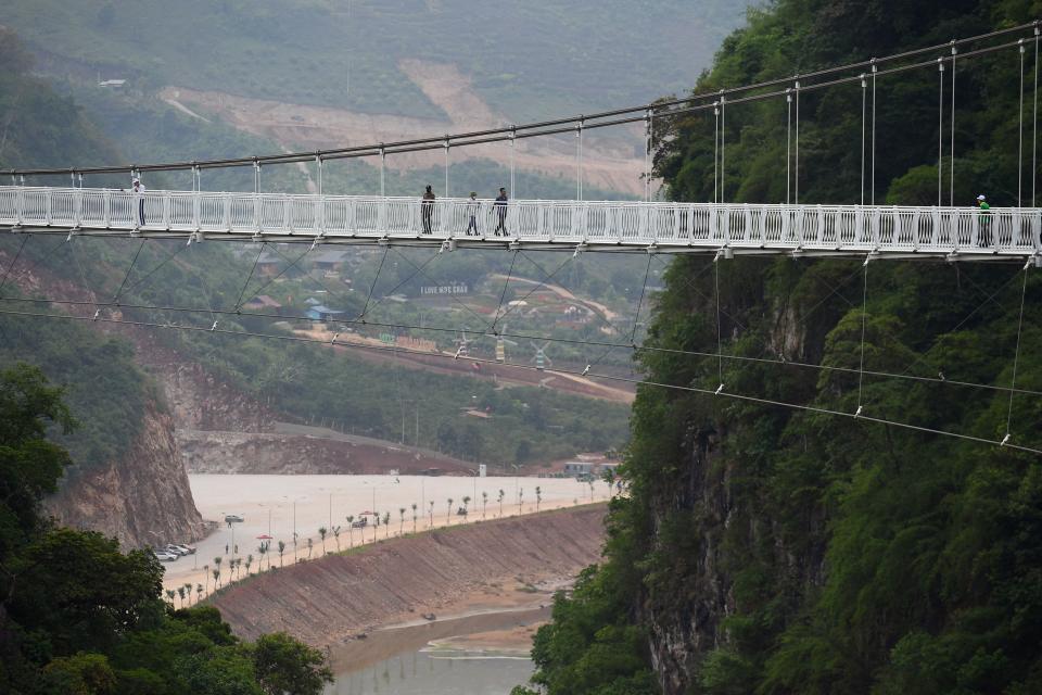 people walk across the Bach Long glass bridge in the Moc Chau district in Vietnam's Son La province