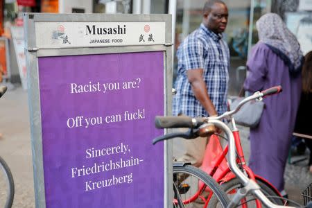 People walk past a sign in Berlin's Kreuzberg district, Germany, August 19, 2016. Picture taken August 19, 2016. REUTERS/Axel Schmidt