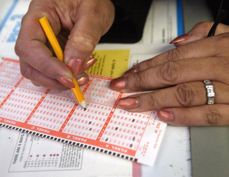 A lottery player selects her numbers on a Powerball ticket.