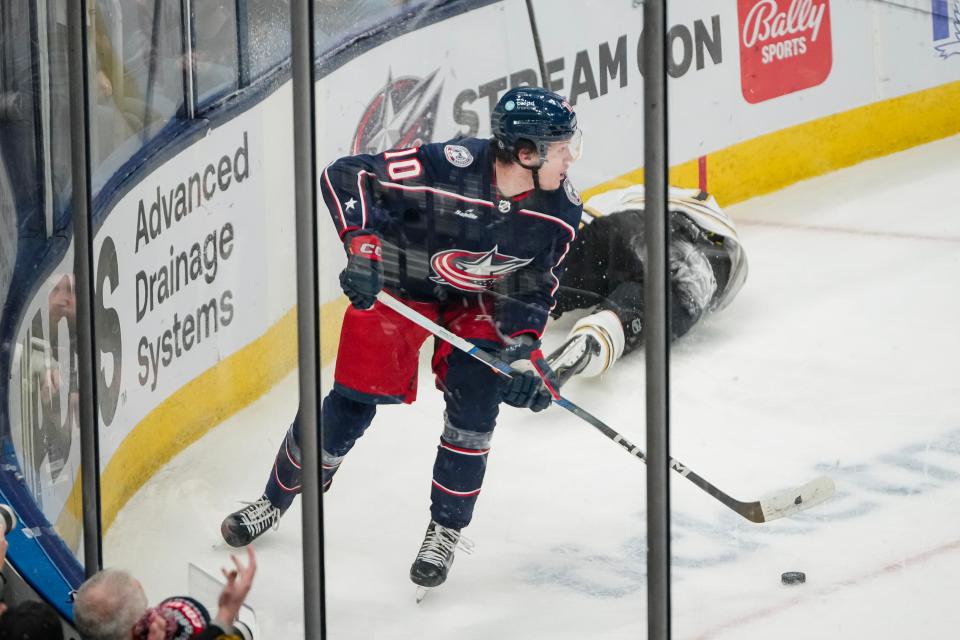 Nov 27, 2023; Columbus, Ohio, USA; Columbus Blue Jackets left wing Dmitri Voronkov (10) skates away with the puck after colliding with Boston Bruins defenseman Charlie McAvoy (73) during the second period of the NHL game at Nationwide Arena.
