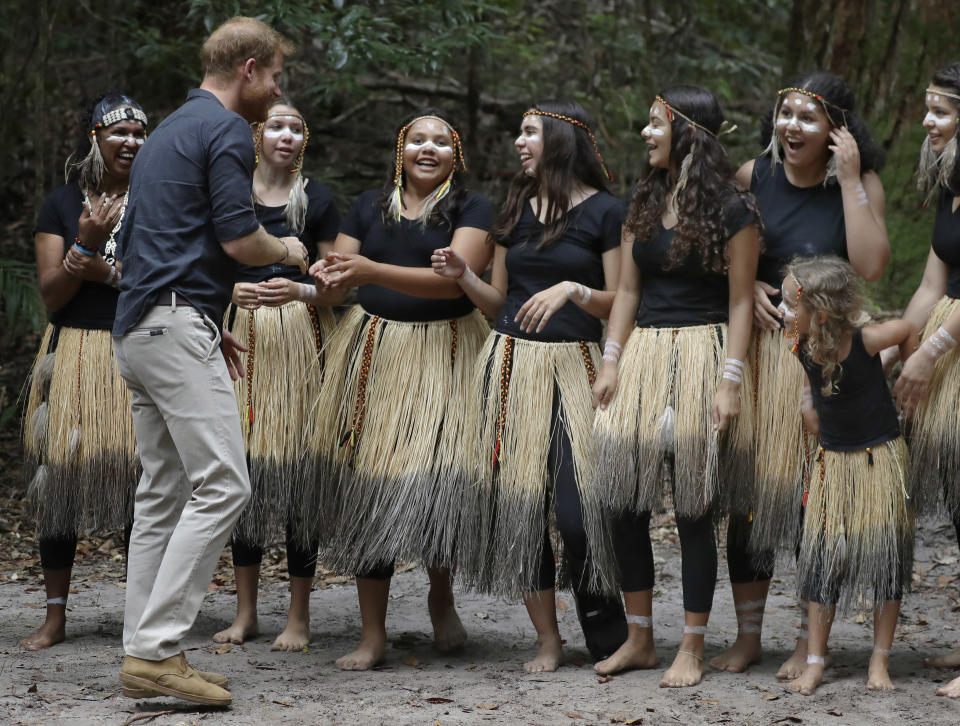 Britain's Prince Harry meets local dancers after the unveiling of the Queens Commonwealth Canopy at Pile Valley, K'gari during a visit to Fraser Island, Australia, Monday, Oct. 22, 2018. Prince Harry and his wife Meghan are on day seven of their 16-day tour of Australia and the South Pacific. (AP Photo/Kirsty Wigglesworth)