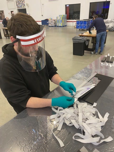 A worker assembles personal protective equipment.