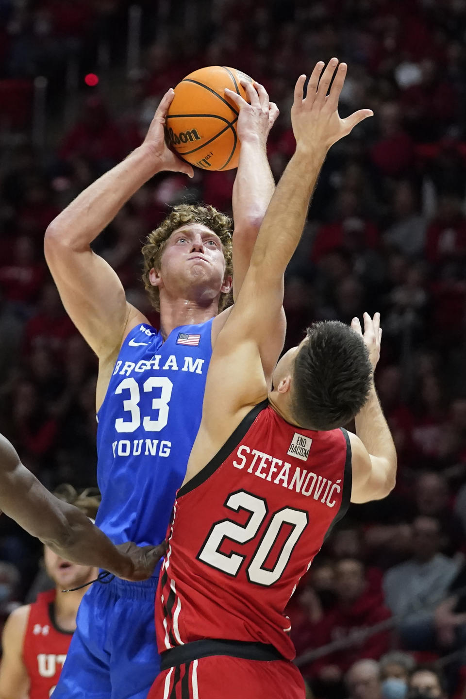 BYU forward Caleb Lohner (33) shoots as Utah guard Lazar Stefanovic (20) defends during the first half of an NCAA college basketball game Saturday, Nov. 27, 2021, in Salt Lake City. (AP Photo/Rick Bowmer)