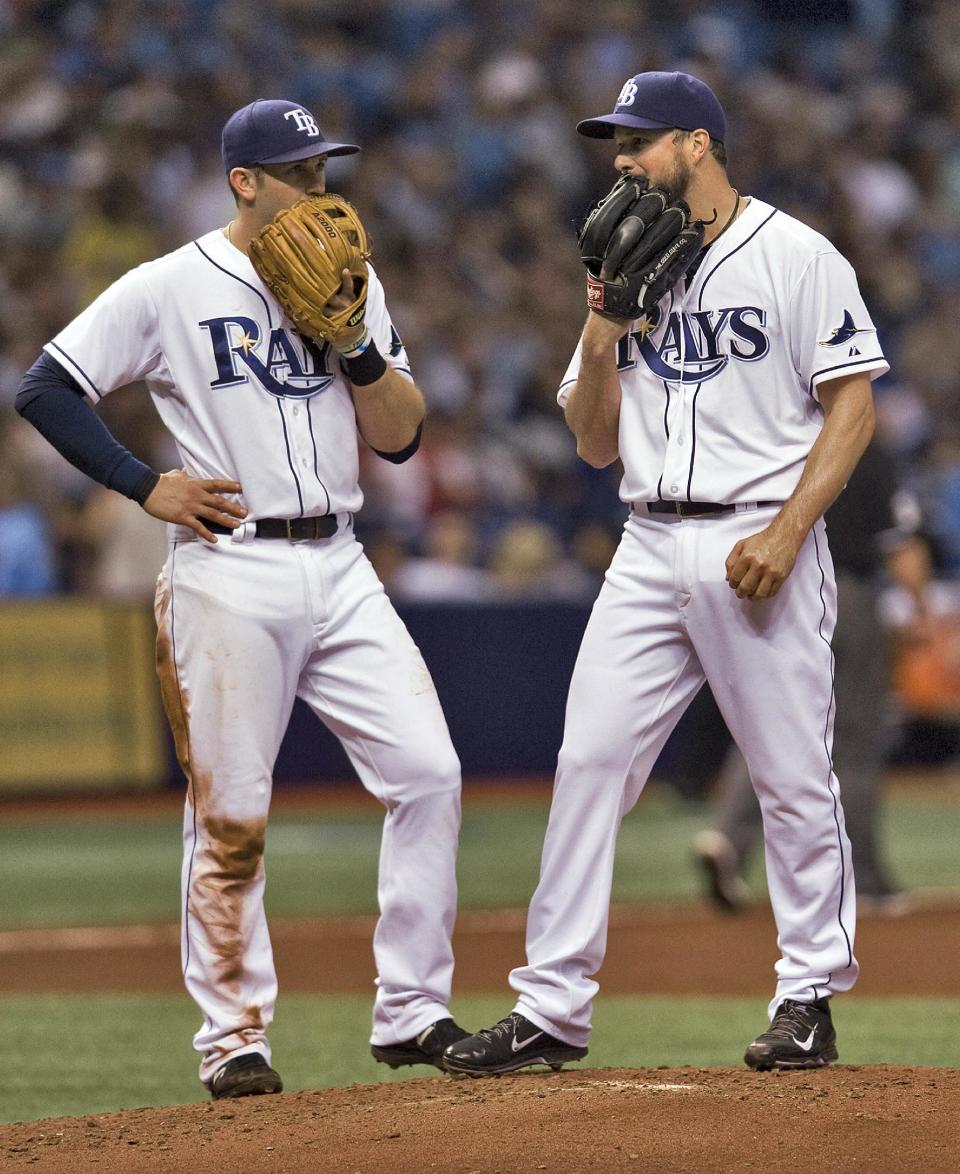 Tampa Bay Rays third baseman Evan Longoria talks with starting pitcher Erik Bedard, right, as Bedard waits on the mound to be pulled during the fourth inning of a baseball game against the New York Yankees on Friday, April 18, 2014, in St. Petersburg, Fla. (AP Photo/Steve Nesius)