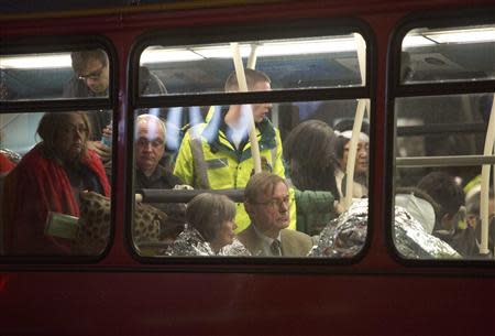 People receive medical attention on a bus after part of the ceiling at the Apollo Theatre on Shaftesbury Avenue collapsed in central London December 19, 2013. REUTERS/Neil Hall