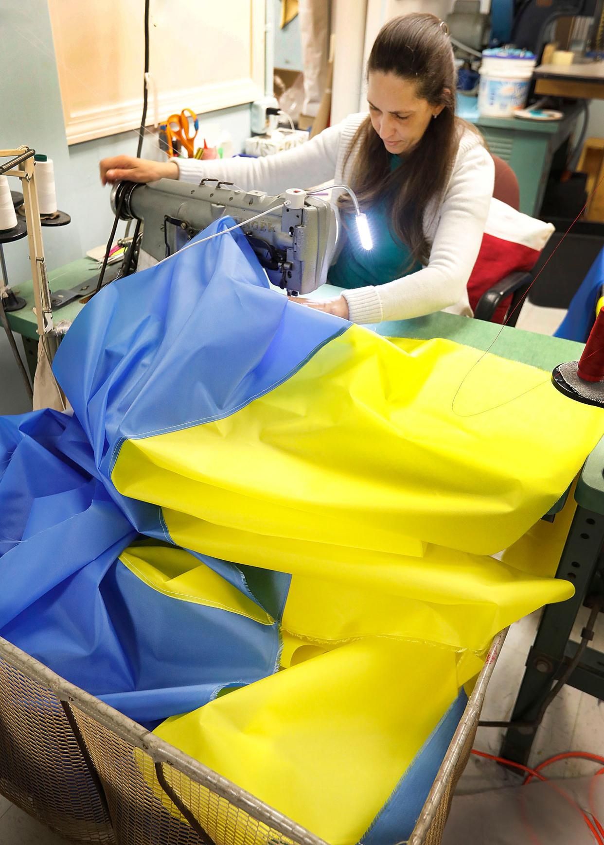 Seamstress Shalea Almeida, of Eagle Flag of America Inc. in Hingham, sews Ukrainian flags for which demand is high on Thursday, March 3, 2022.