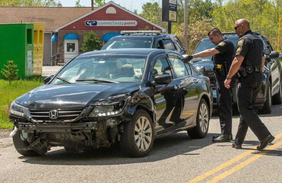 Paxton and Leicester police officers look at a damaged stolen car Tuesday on Mannville Street at Route 9 in Leicester.