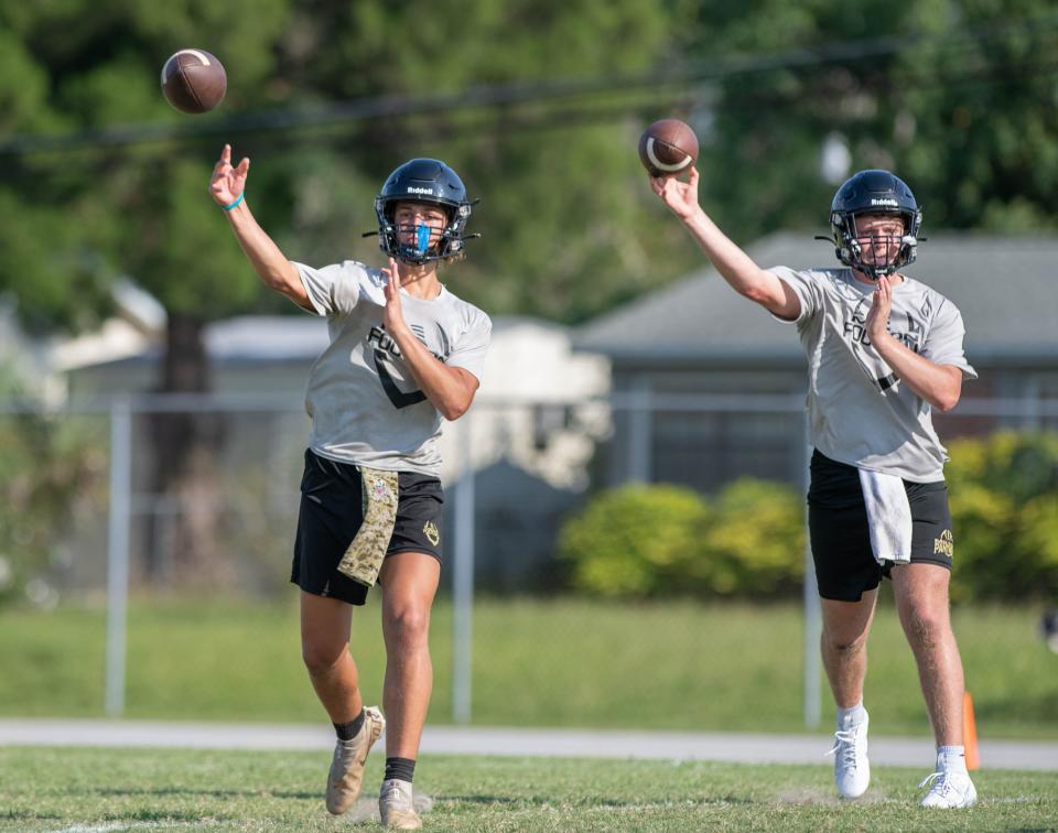 Quarterbacks Tate Williams, left, and Ethan Diamond pass during football practice at Milton High School on Tuesday, August 1, 2023. (Syndication: News-Journal)