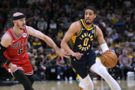 Indiana Pacers guard Tyrese Haliburton (0) drives around Chicago Bulls guard Alex Caruso (6) during the first half of an NBA basketball game in Indianapolis, Wednesday, March 13, 2024. (AP Photo/AJ Mast)