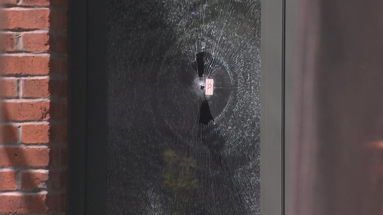 A pierced, cracked windowpane at Isabelle's, a cocktail bar in Yaletown. A number of other small puncture marks were visible on the building's facade.  (Nick Allan/CBC - image credit)