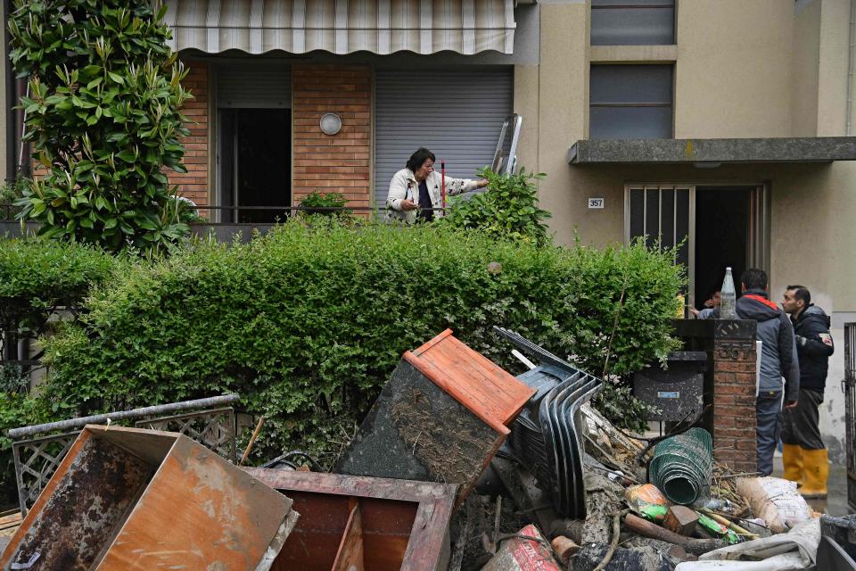 Local residents observe the aftermath of a flooding in a street of the San Rocco district of Cesena on May 17, 2023. Heavy rains have caused major floods in central Italy, where trains were stopped and schools were closed in many towns while people were asked to leave the ground floors of their homes and to avoid going out.